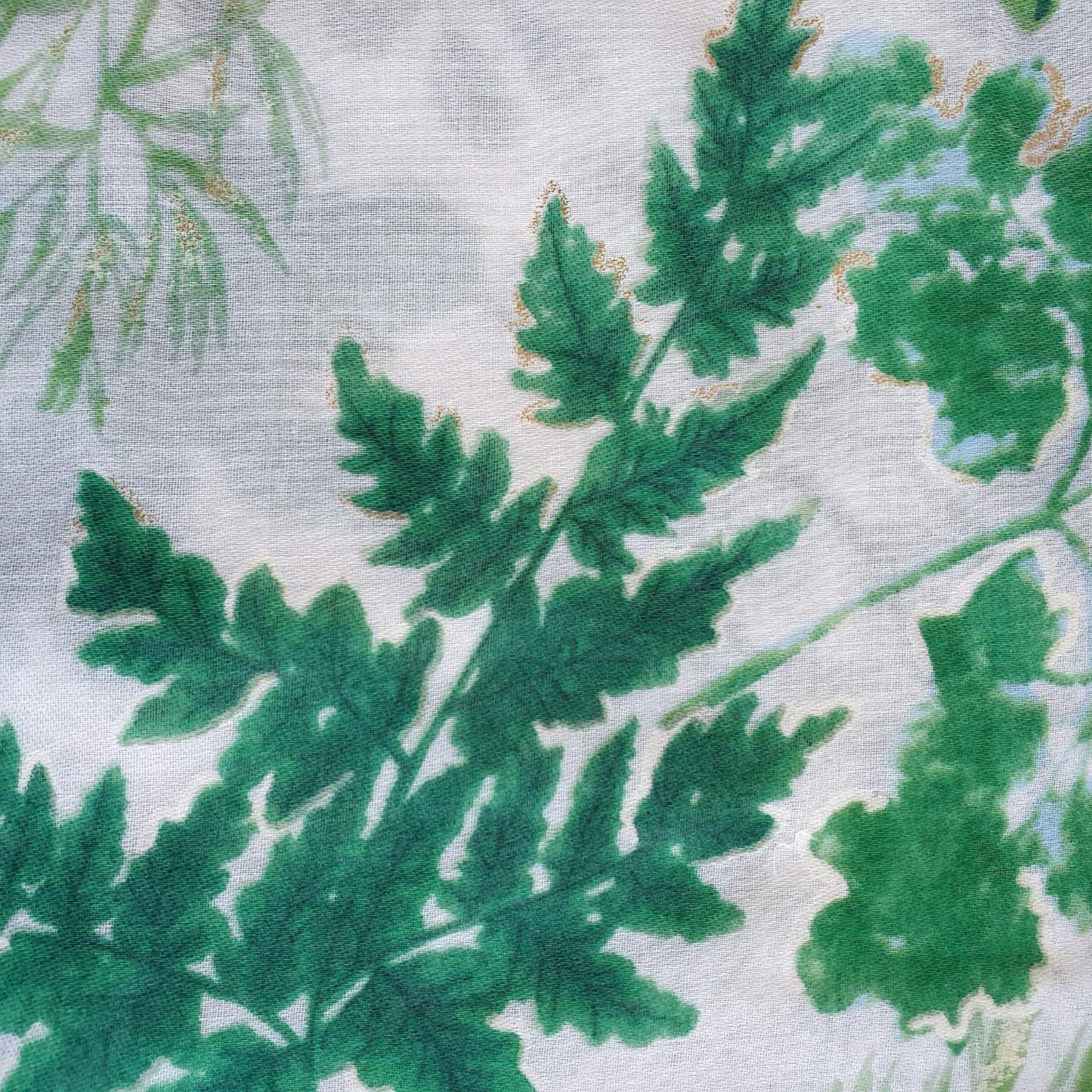Close-up of green leafy pattern on a textured fabric background