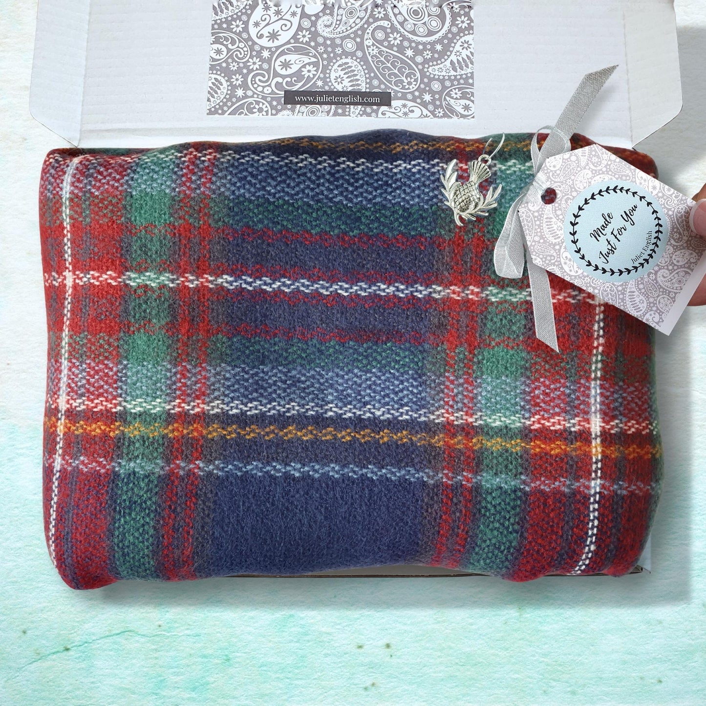 Plaid blanket with a tag on a light blue background