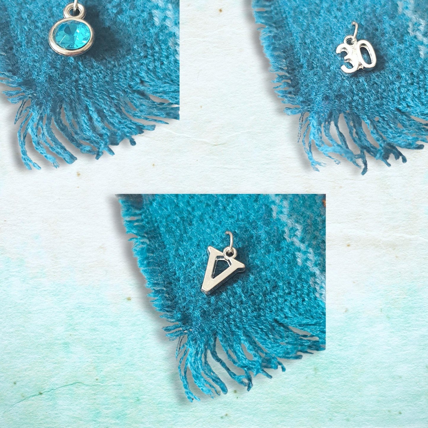 silver charms on woven scarf on a light blue background