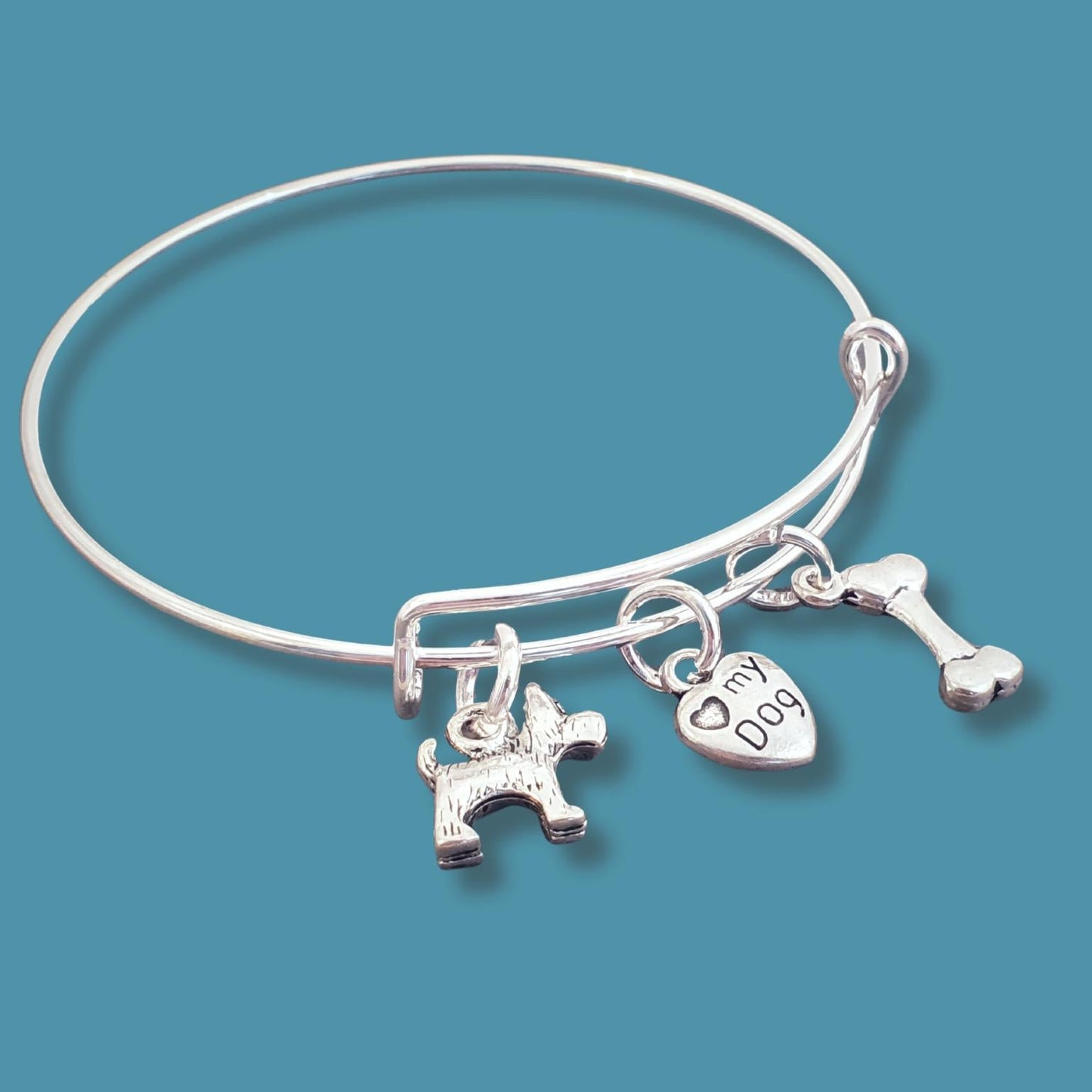 Silver bracelet with dog-themed charms on a blue background