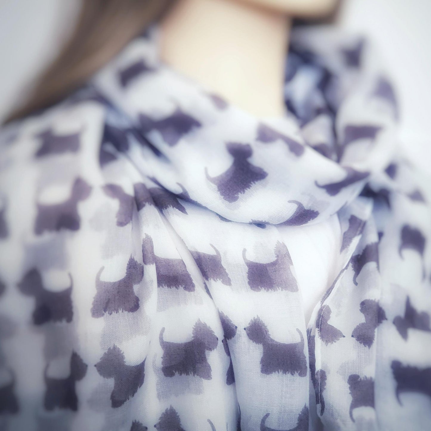 Person wearing a scotty dog patterned scarf with a blurred background