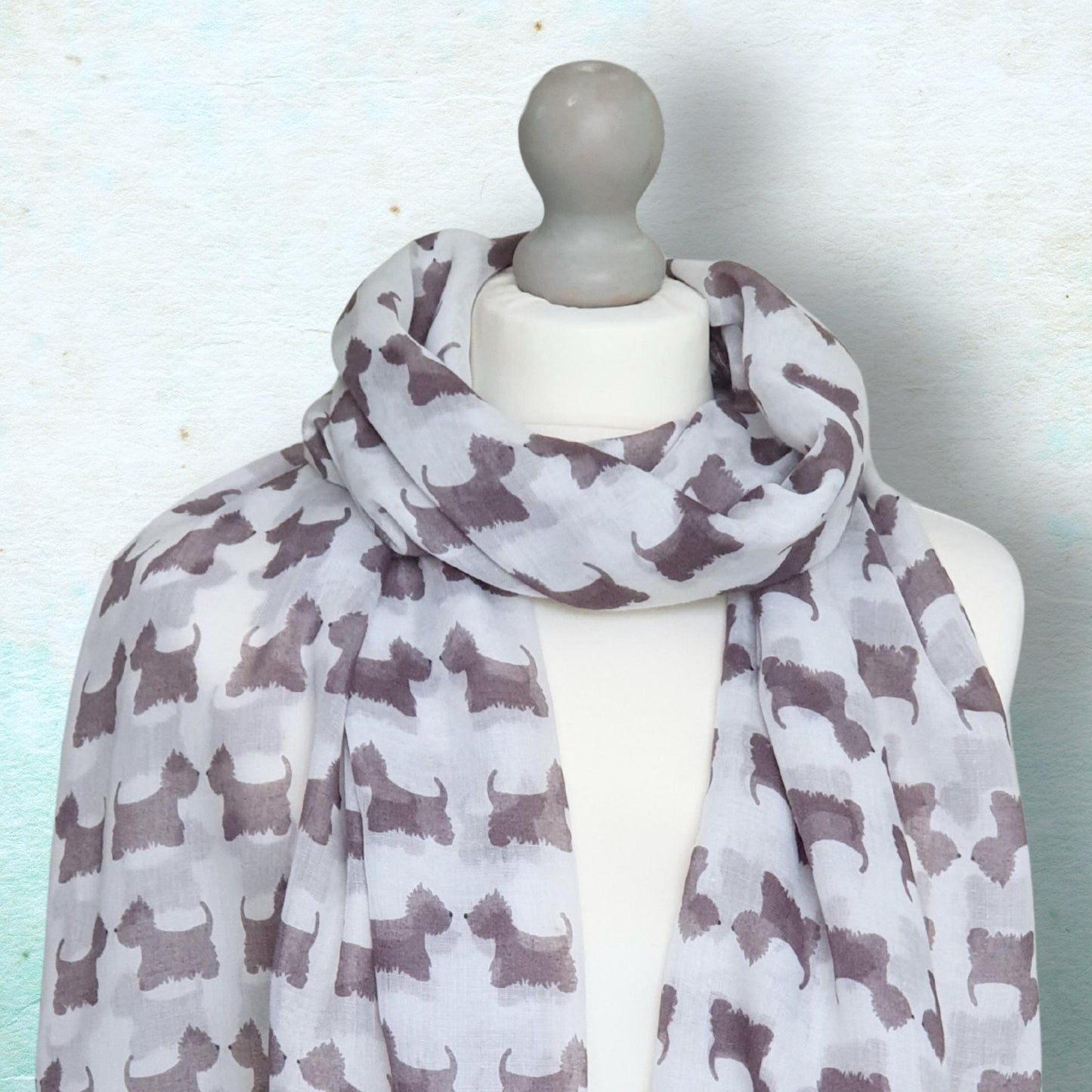 Scarf with scotty dog pattern on a mannequin against a light blue background