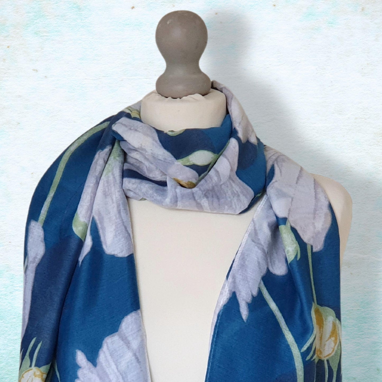 Mannequin wearing a blue floral scarf against a light background