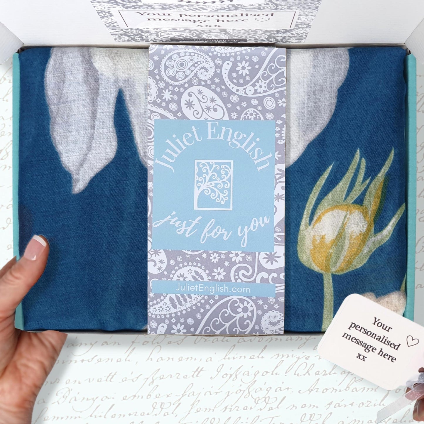Scarf featuring a blue design with floral elements with a personalised message card