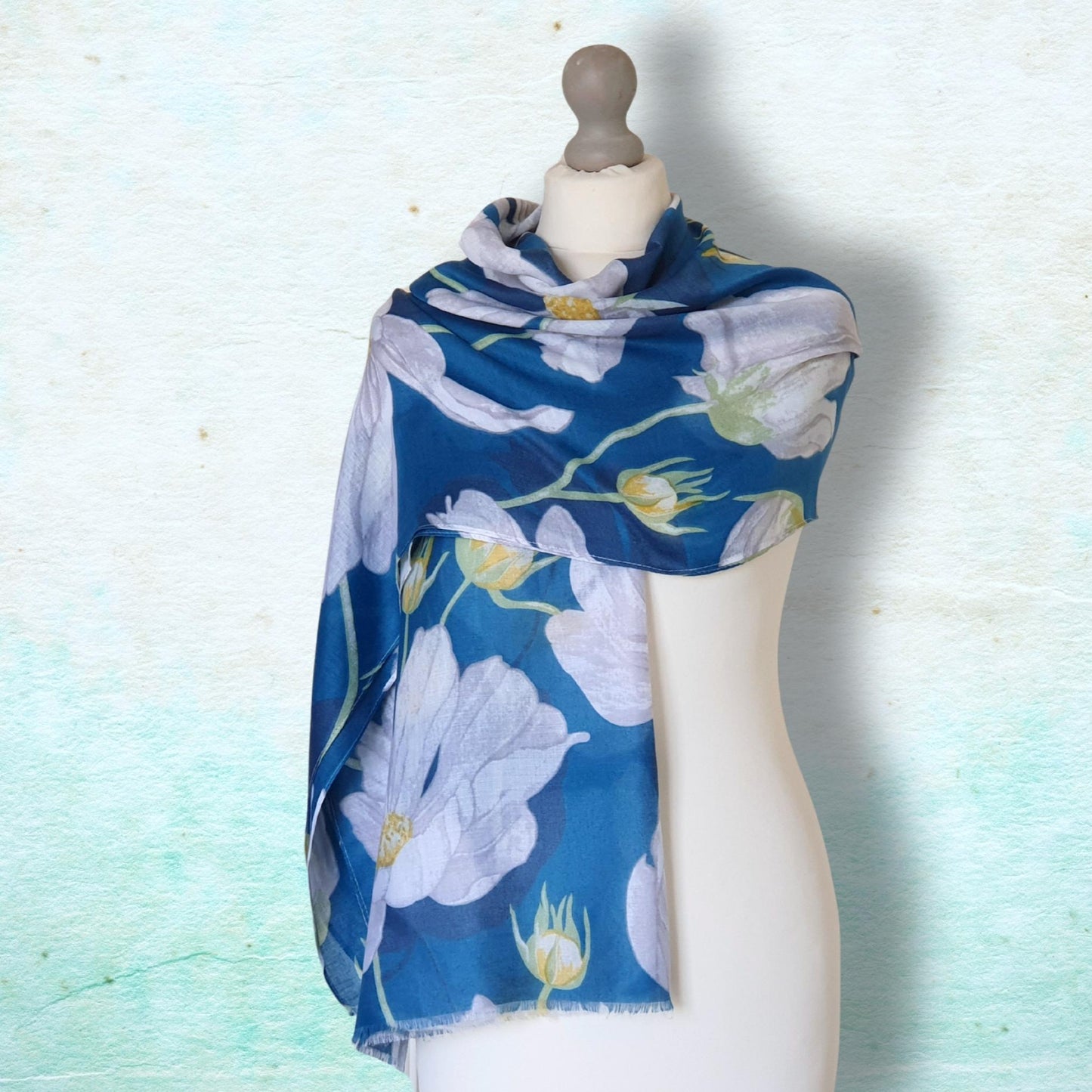 Blue floral scarf on a mannequin against a light blue background