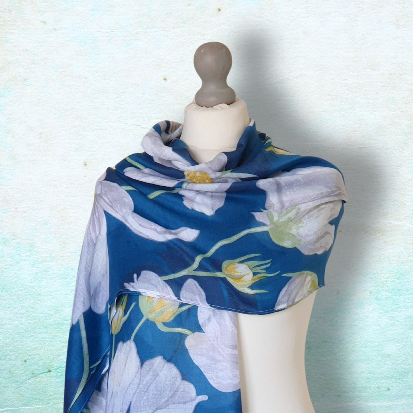 Blue floral scarf on a mannequin against a light blue background