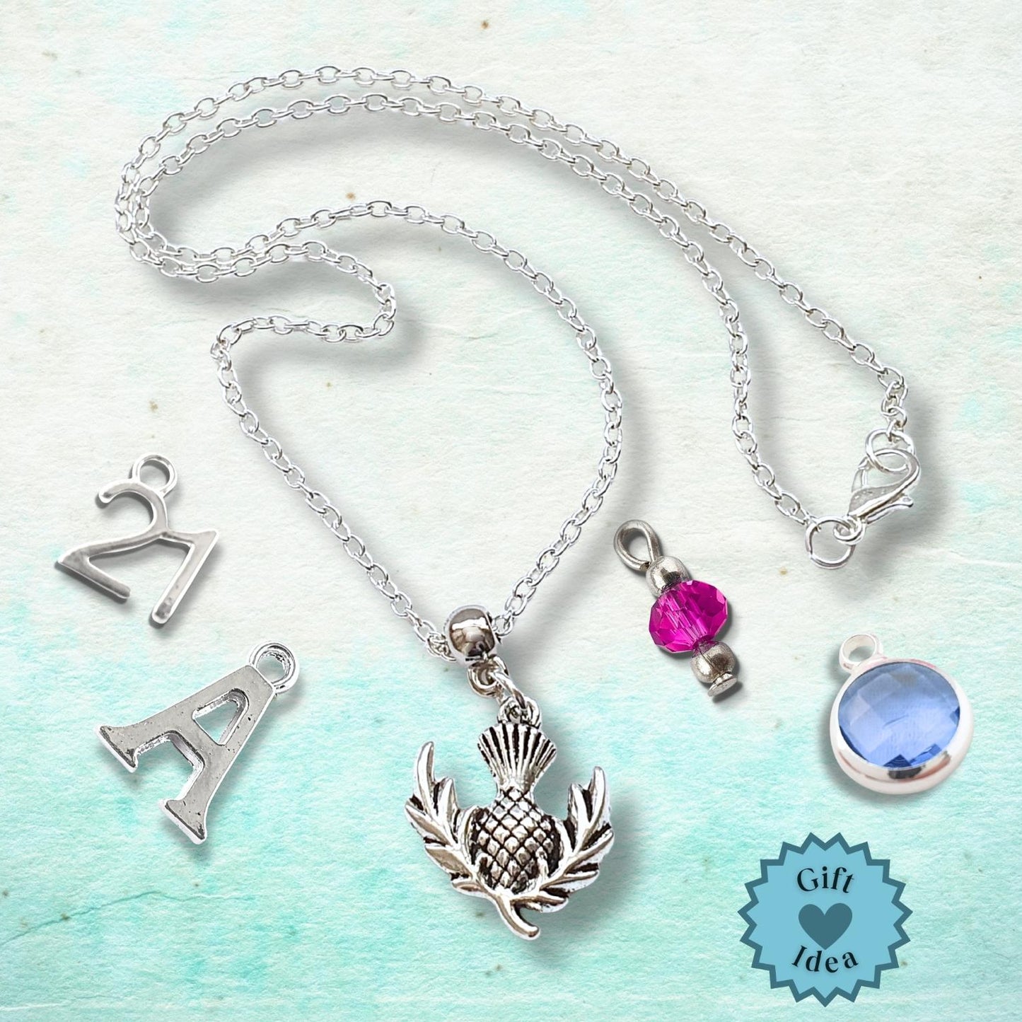 Silver necklace with various pendants on a light blue background