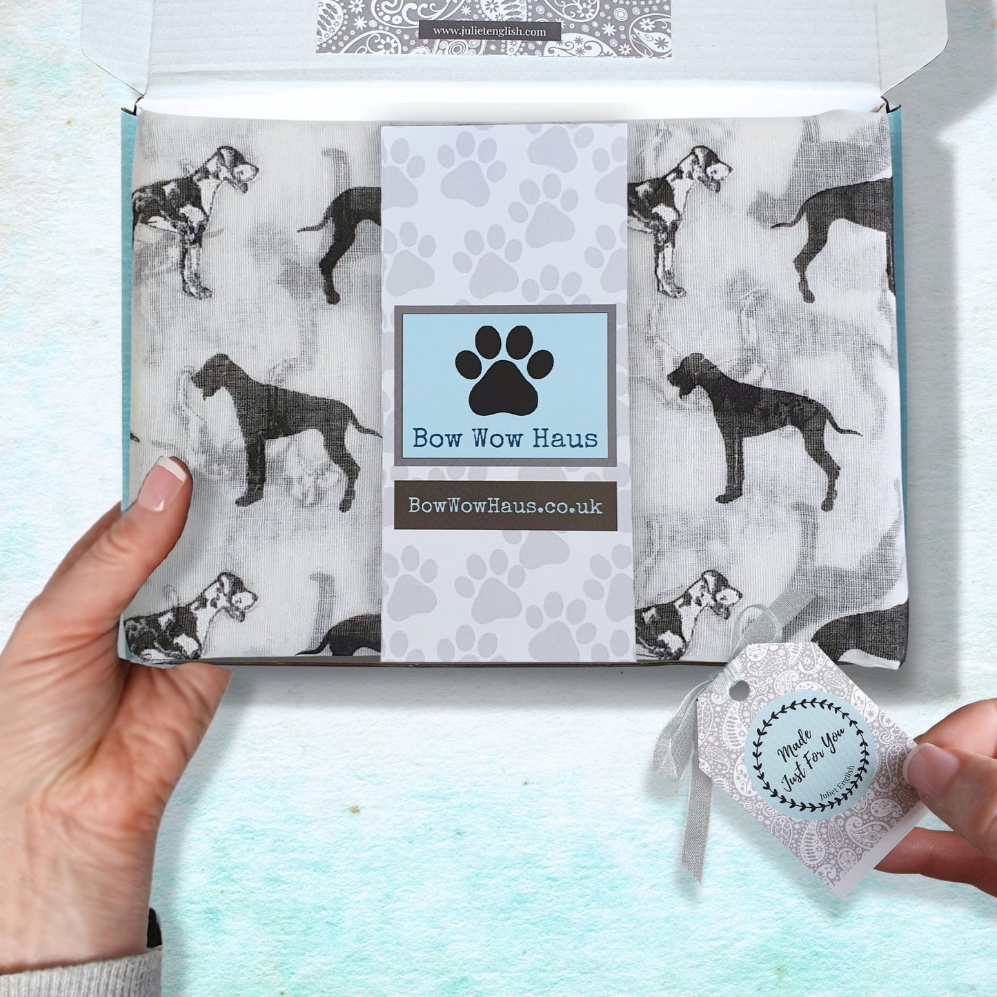 Great dane dog print scarf in box with 'Bow Wow Haus' branding held by a person.