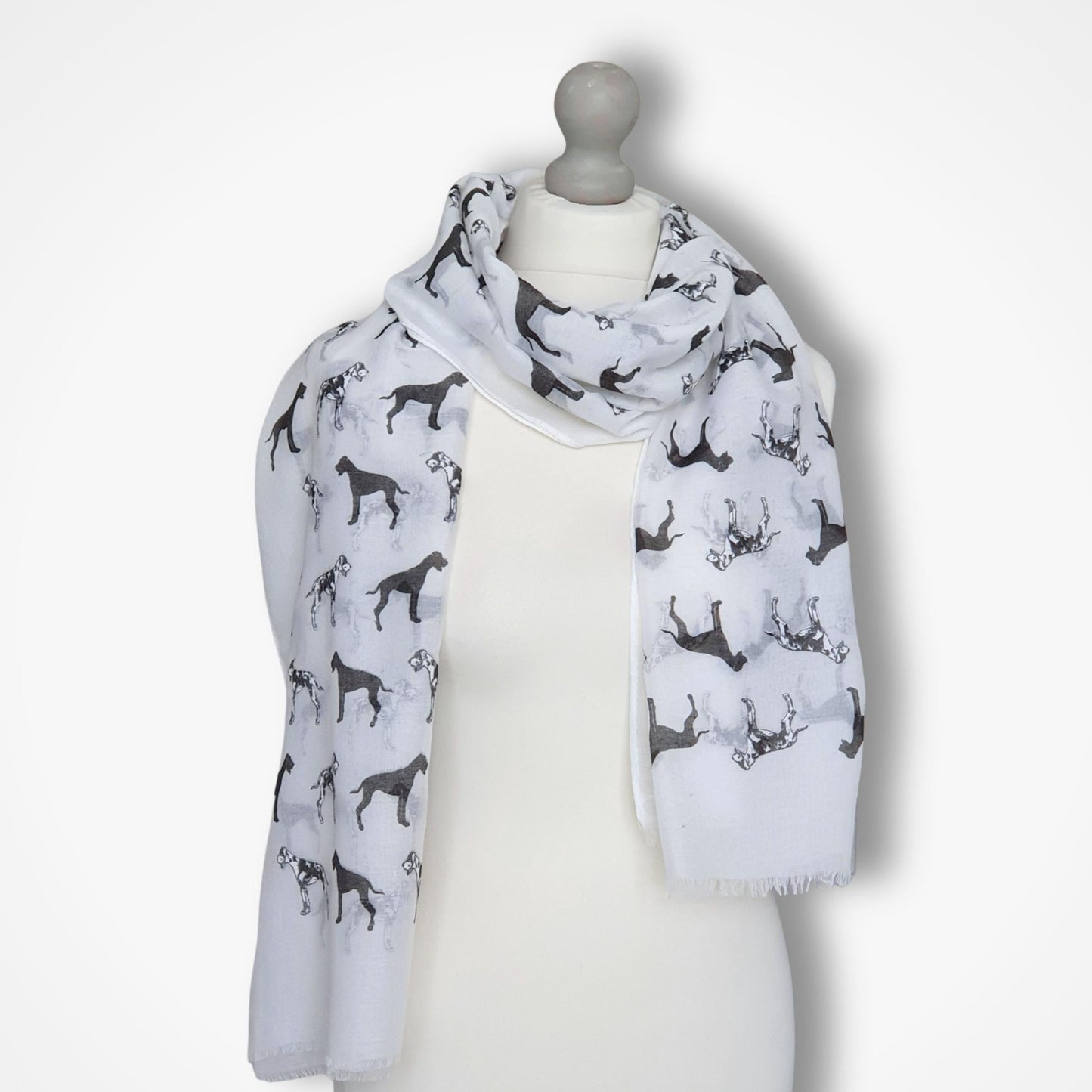 Scarf with great dane dog pattern draped over a mannequin on a white background
