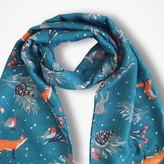 Teal scarf with forest animal pattern on a white background