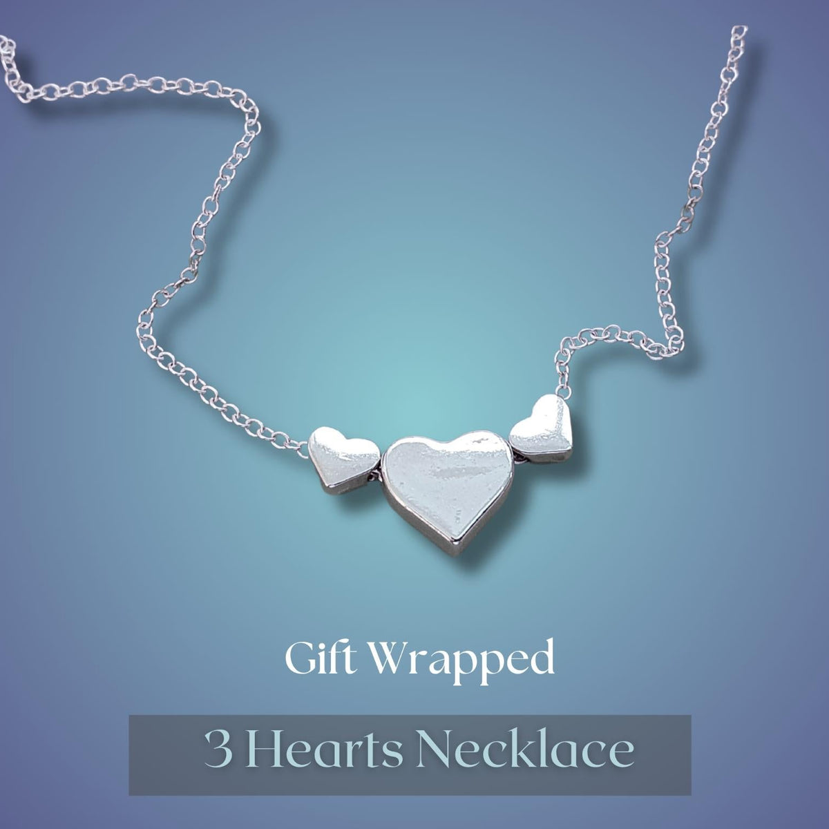 A silver 3-heart necklace with a centre heart and side hearts, displayed on a blue gradient background with 'Gift Wrapped 3 Hearts Necklace' text below.