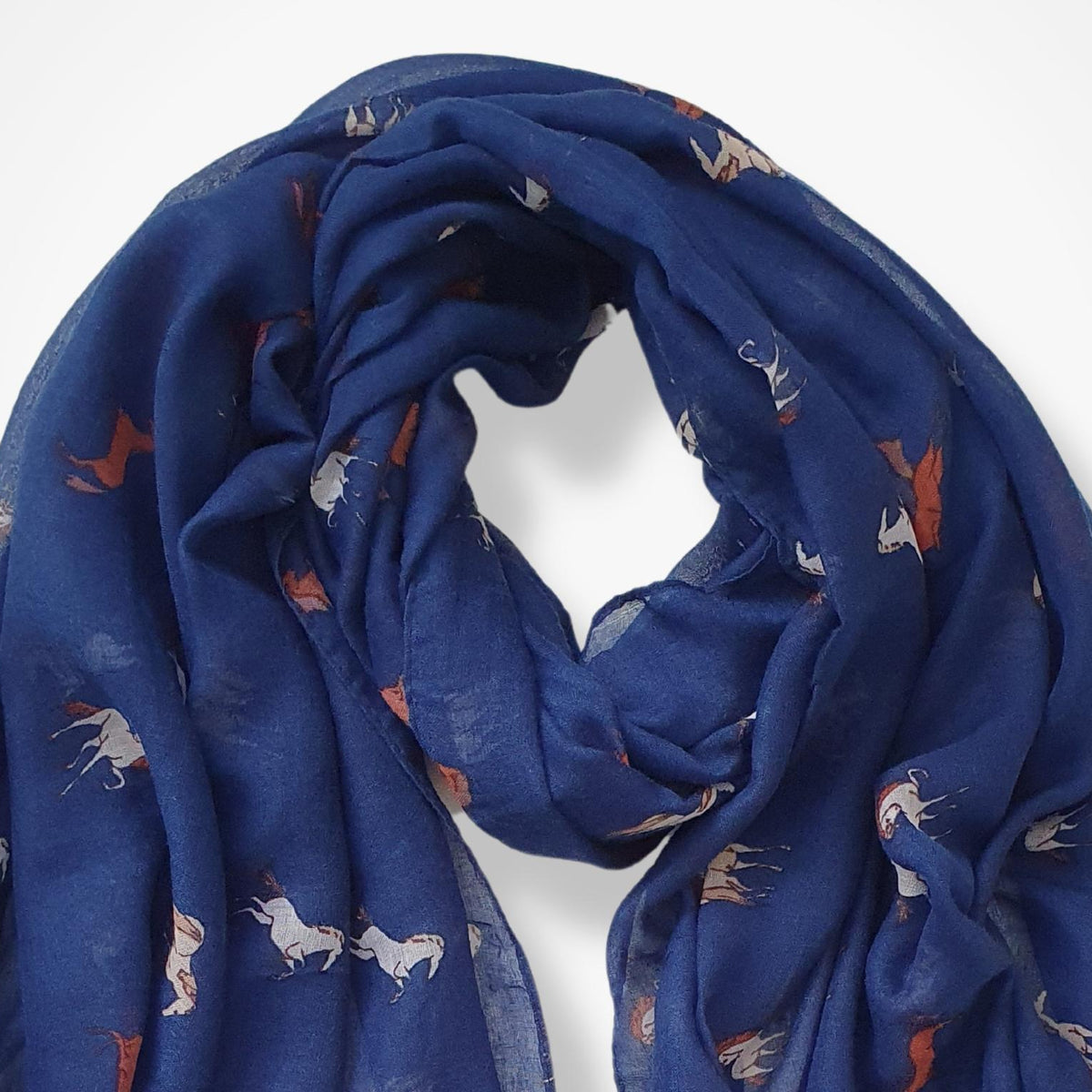 A blue lightweight scarf with a repeating pattern of small white and brown horses, draped against a plain white background.