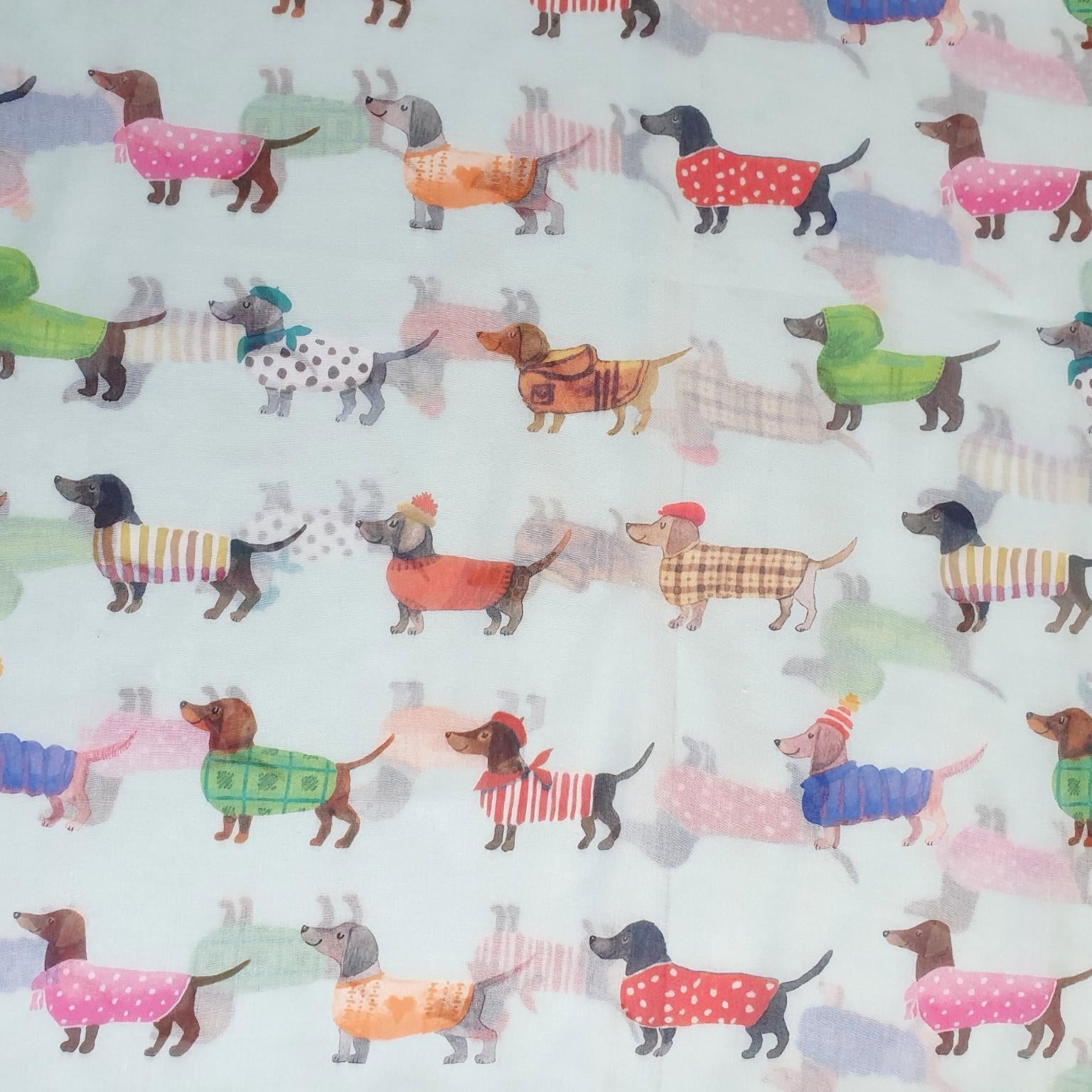 Pattern of colorful dogs in sweaters on a light blue background