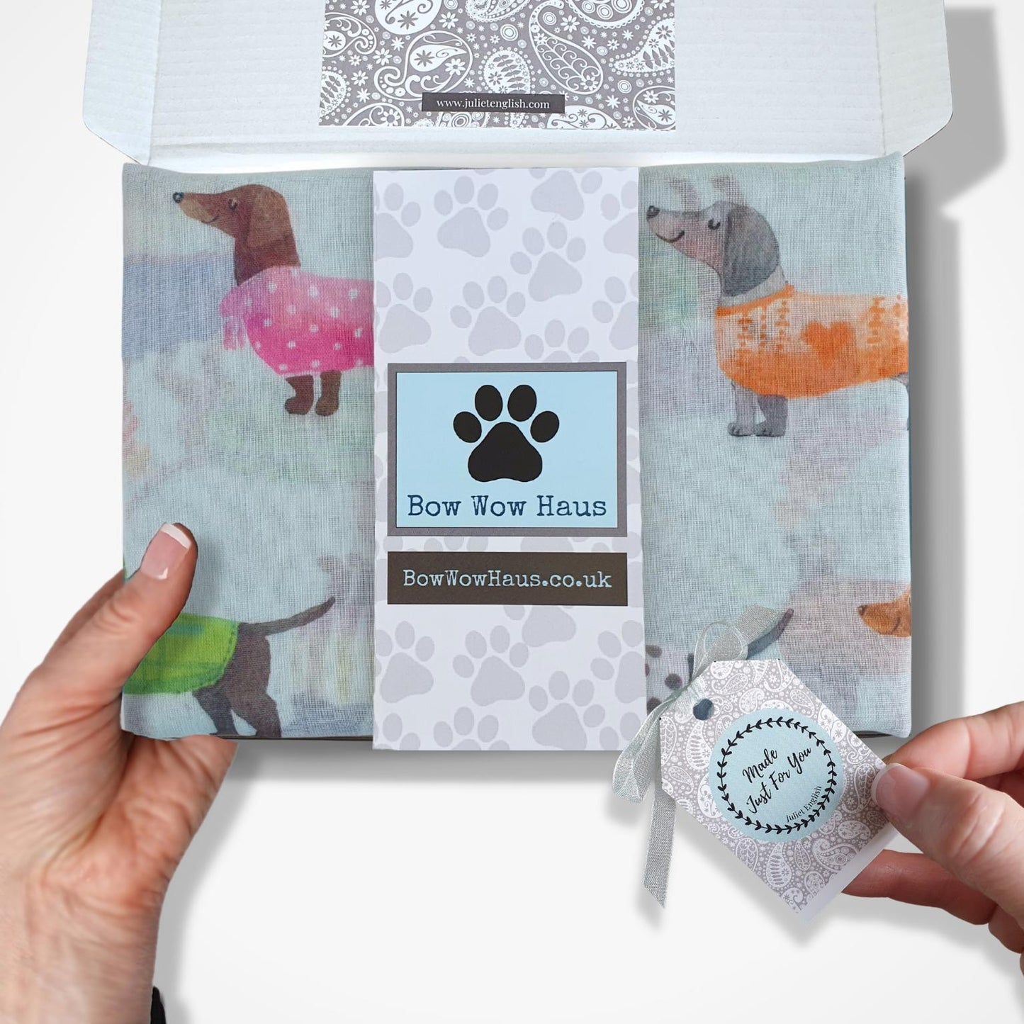 Packaged scarf with sausage dog design and 'Bow Wow Haus' branding.