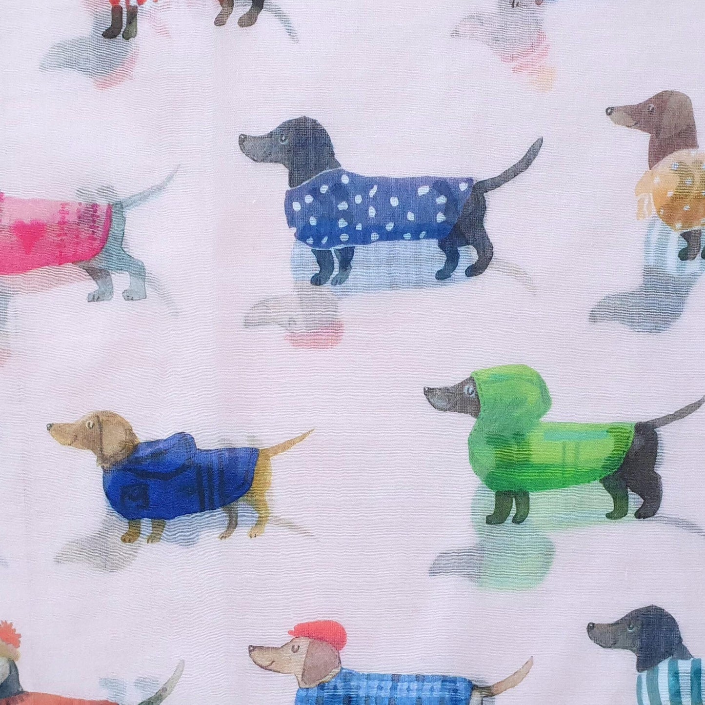 Pattern of small dogs in colorful raincoats on a light background
