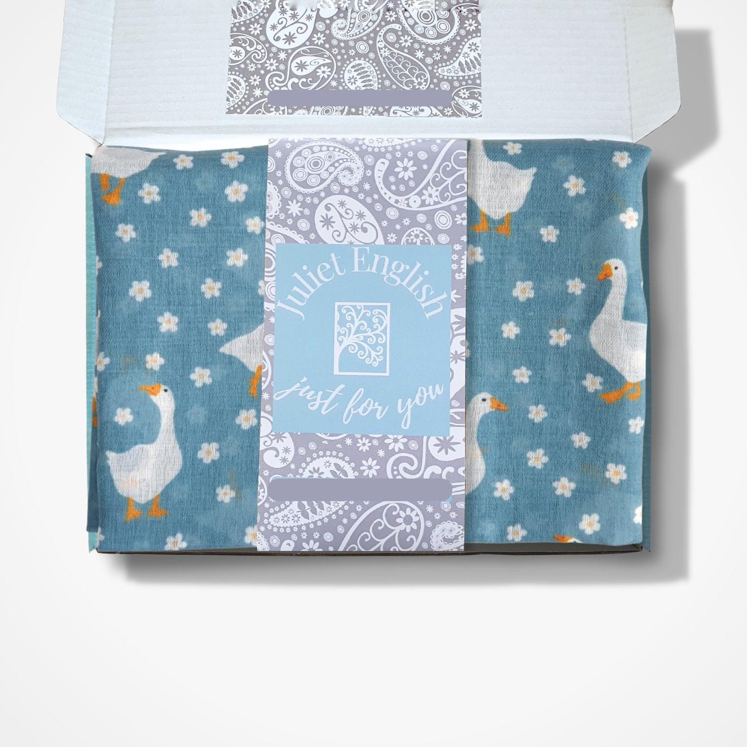 scarf with goose and daisy pattern in a box on a white background