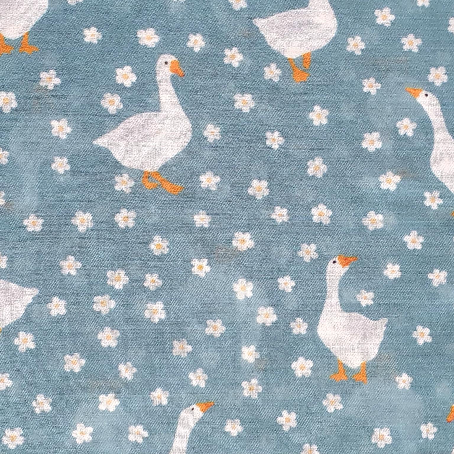 Pattern of geese and flowers on a blue background