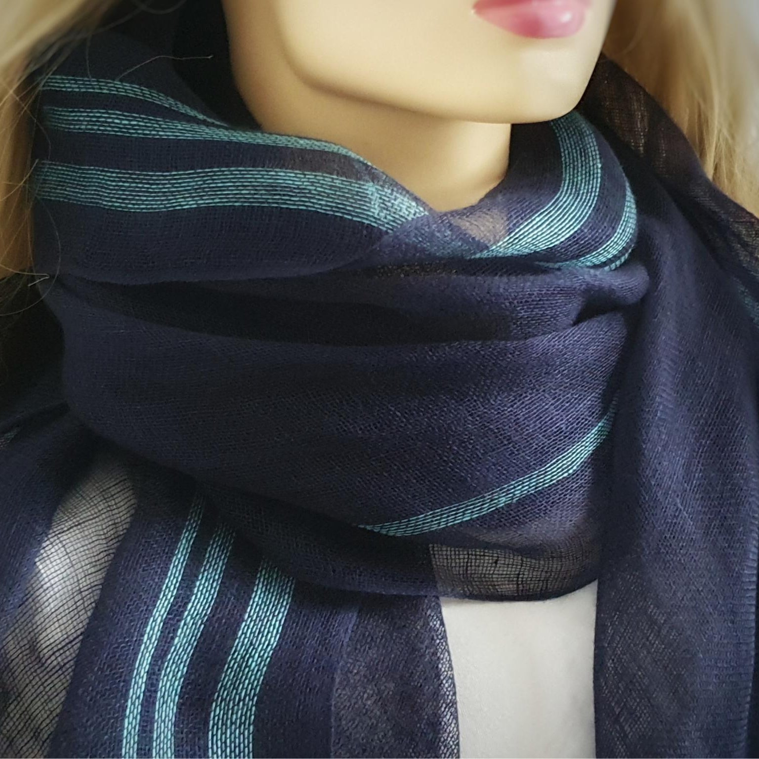 Mannequin wearing a dark blue scarf with green stripes
