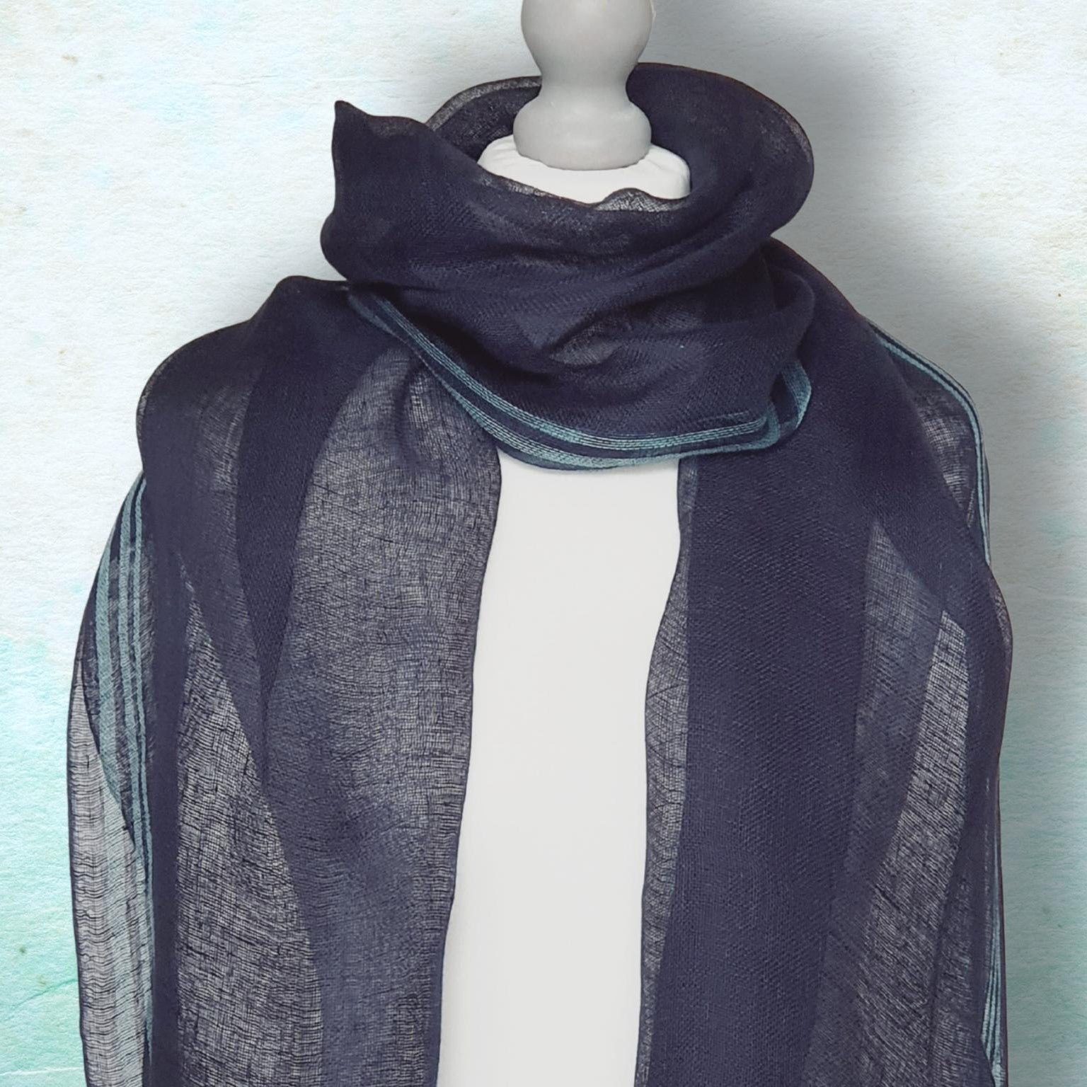 Navy blue scarf draped over a mannequin against a light background