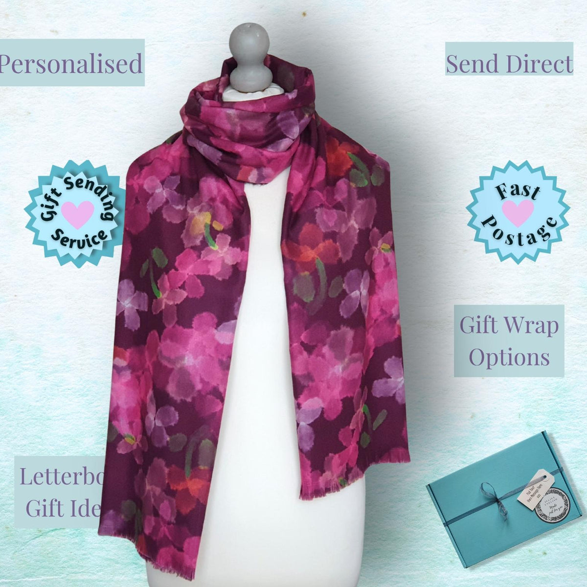 A floral scarf displayed on a white mannequin torso against a pale blue textured background, with overlaid text and badges reading 'Personalised', 'Send Direct', 'Gift Sending Service', 'Fast Postage', 'Gift Wrap Options', and 'Letterbox Gift Ideas'. A small teal gift box is shown in the lower right corner.