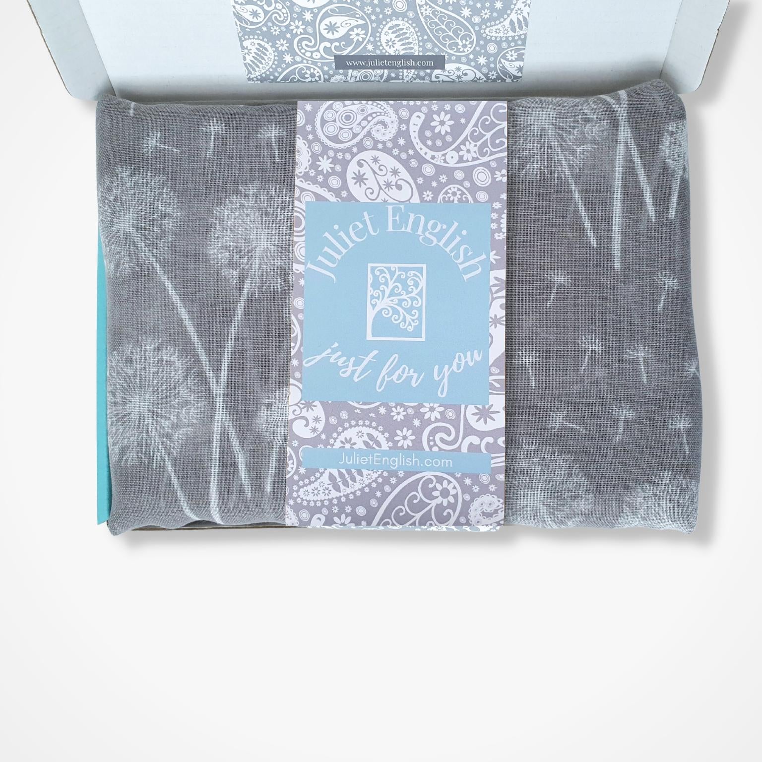 Packaged scarf with dandelion design and 'Juliet English' branding on a white background