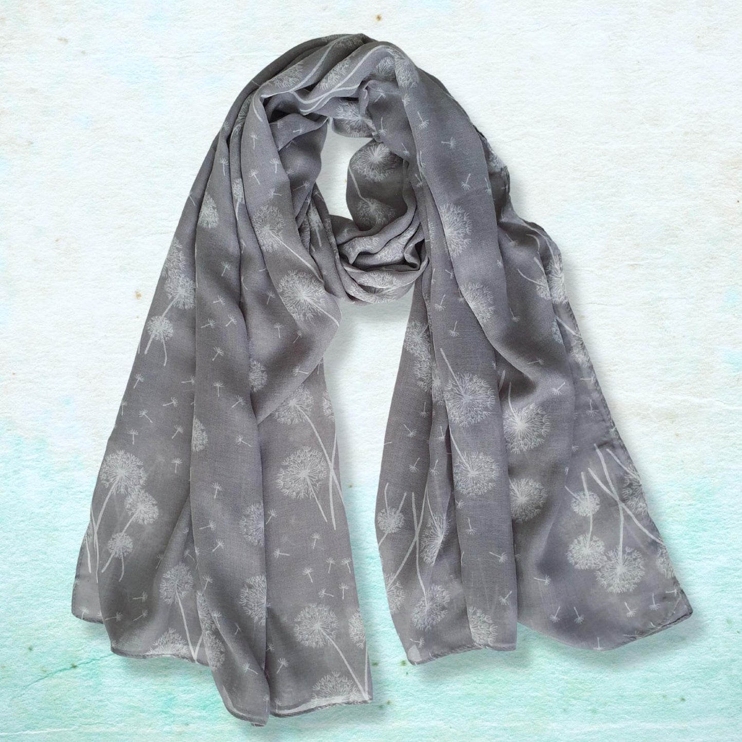 Gray scarf with subtle dandelion pattern on a light blue textured background