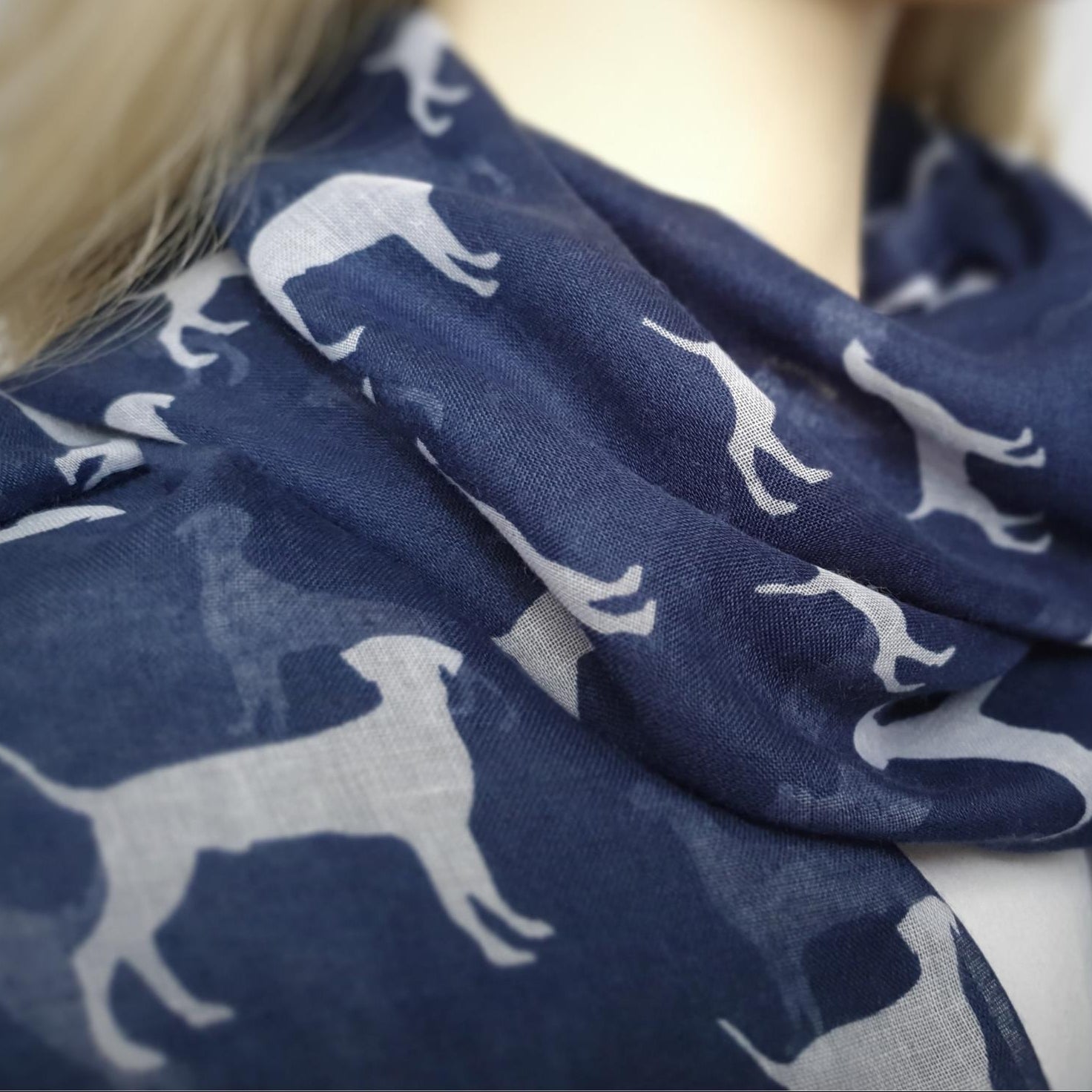 Navy blue scarf with white dog pattern worn by a person