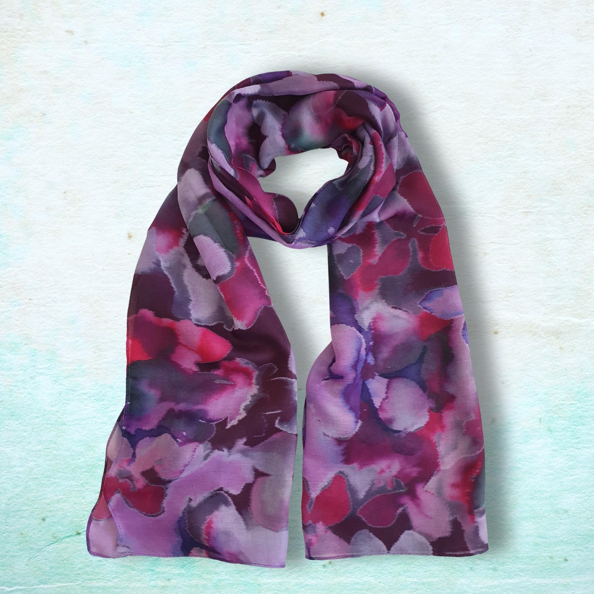 Purple and pink patterned scarf on a light blue background