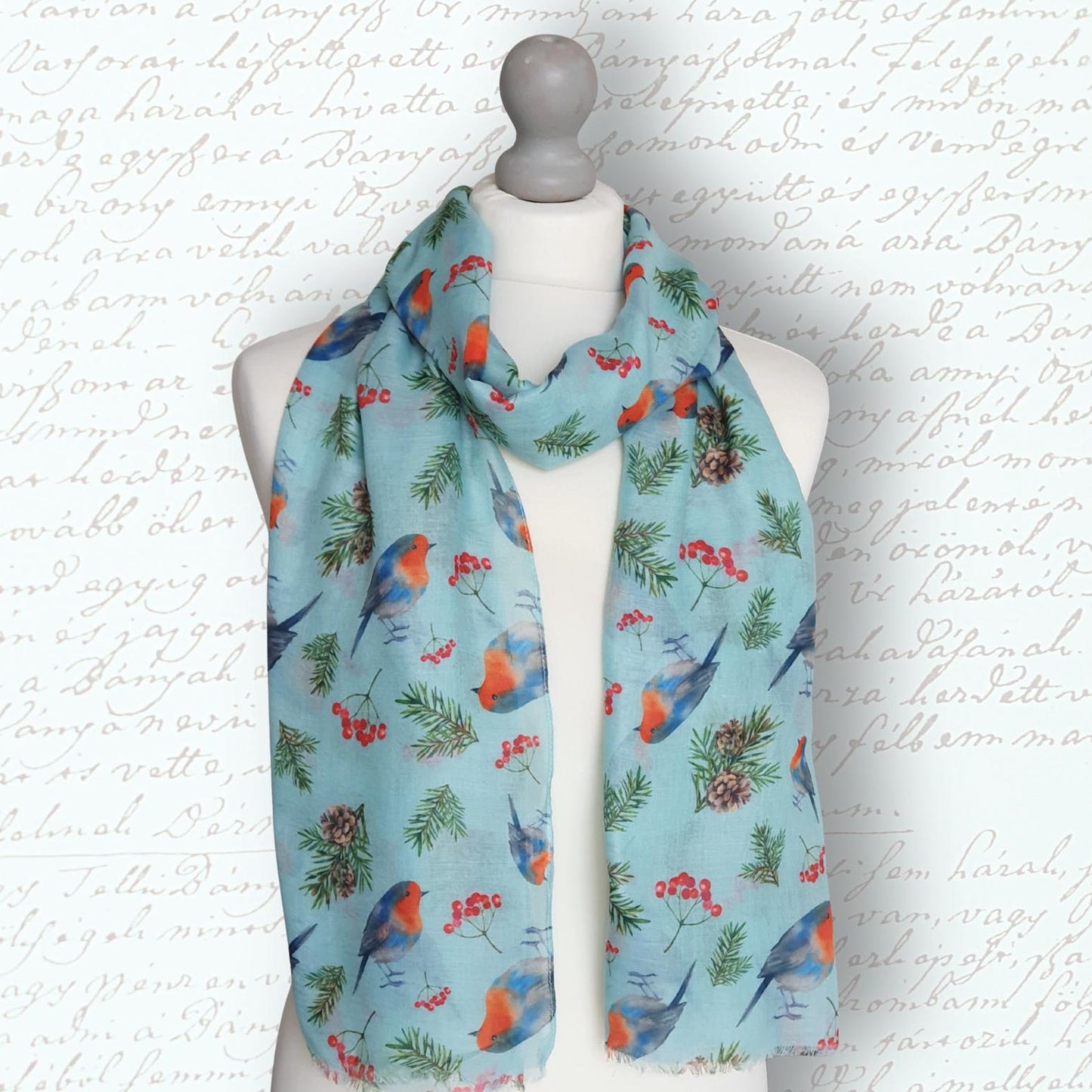 Scarf with bird and berry pattern on a mannequin against a textured white background