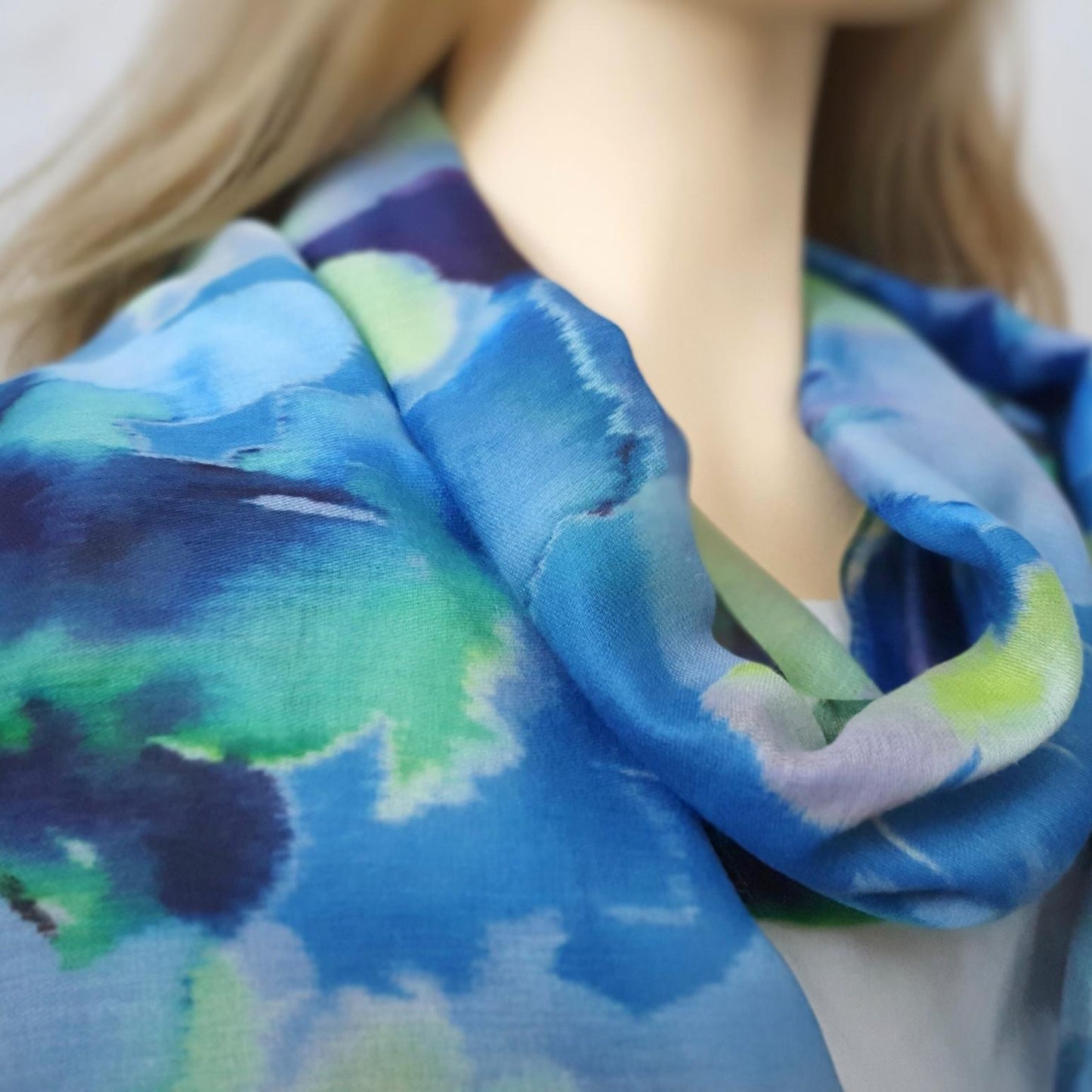 Close-up of a person wearing a blue and green patterned scarf.