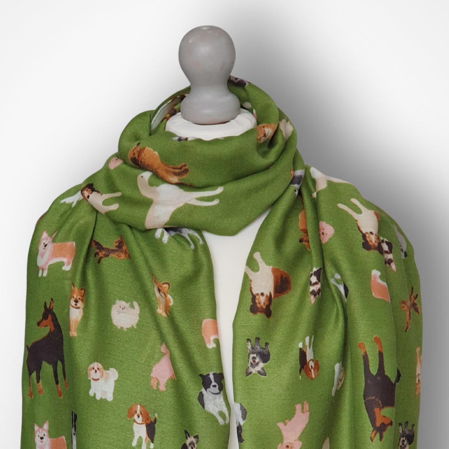 Green scarf with dog pattern on a mannequin against a white background