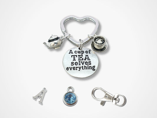 Personalised A Cup Of Tea Solves Everything keyring. A lovely little letterbox birthday gift for a friend. &nbsp;a tiny 3D teapot charm, a disc with the wording A Cup Of Tea Solves Everything and a miniature cup of tea and saucer with a little heart inside. The charms are silver plated and attached with strong silver plated rings 