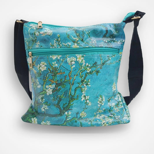 A crossbody shoulder bag featuring a print of Van Gogh's 'Almond Blossom' painting in vibrant turquoise, blue, and white, with black adjustable straps and gold-tone hardware, shown against a plain white background.