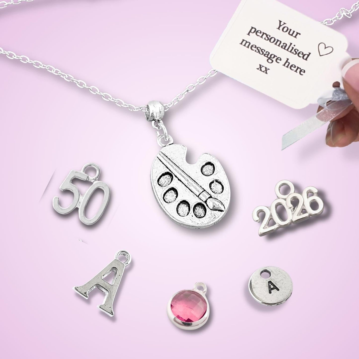 Personalized necklace with various charms on a pink background