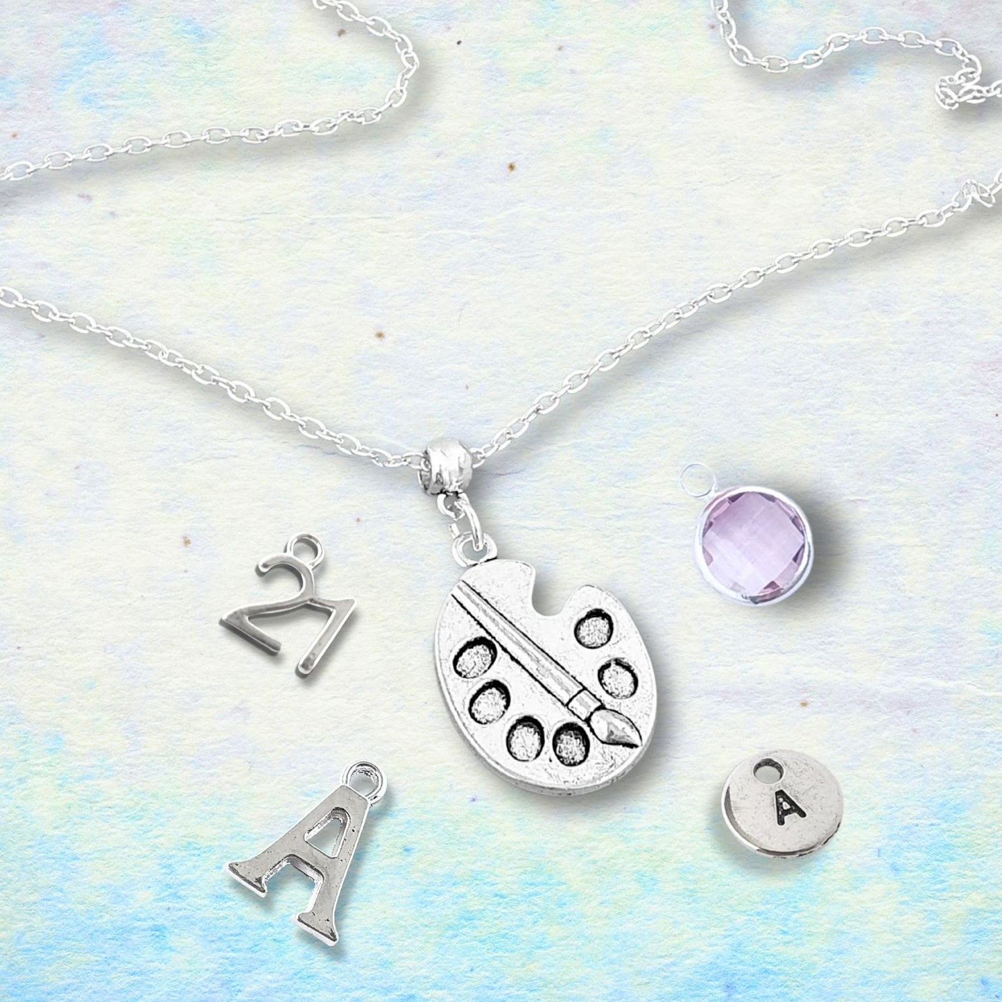Silver necklace with various charms on a light blue and white background