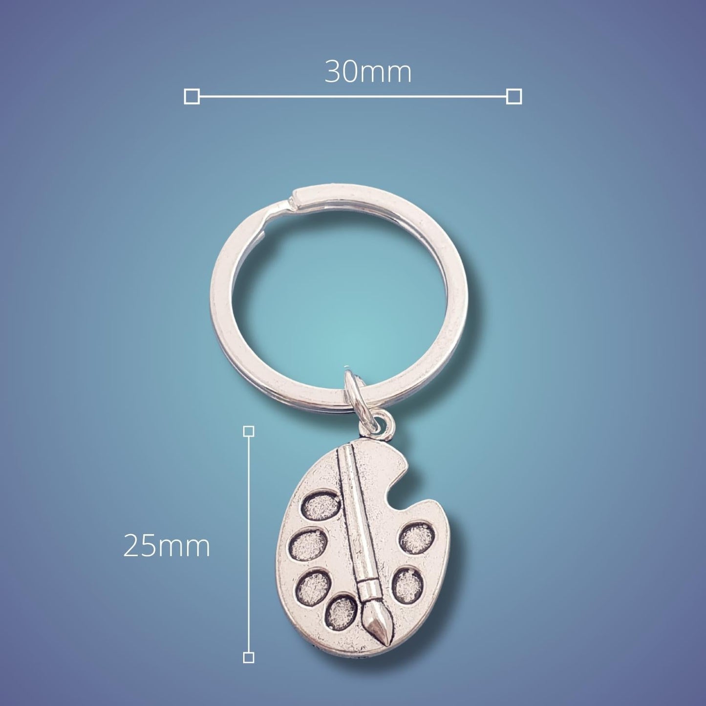 A silver keychain with a small artist paint palette charm and paintbrush detail, shown on a blue gradient background with dimension lines indicating 30mm width and 25mm height.
