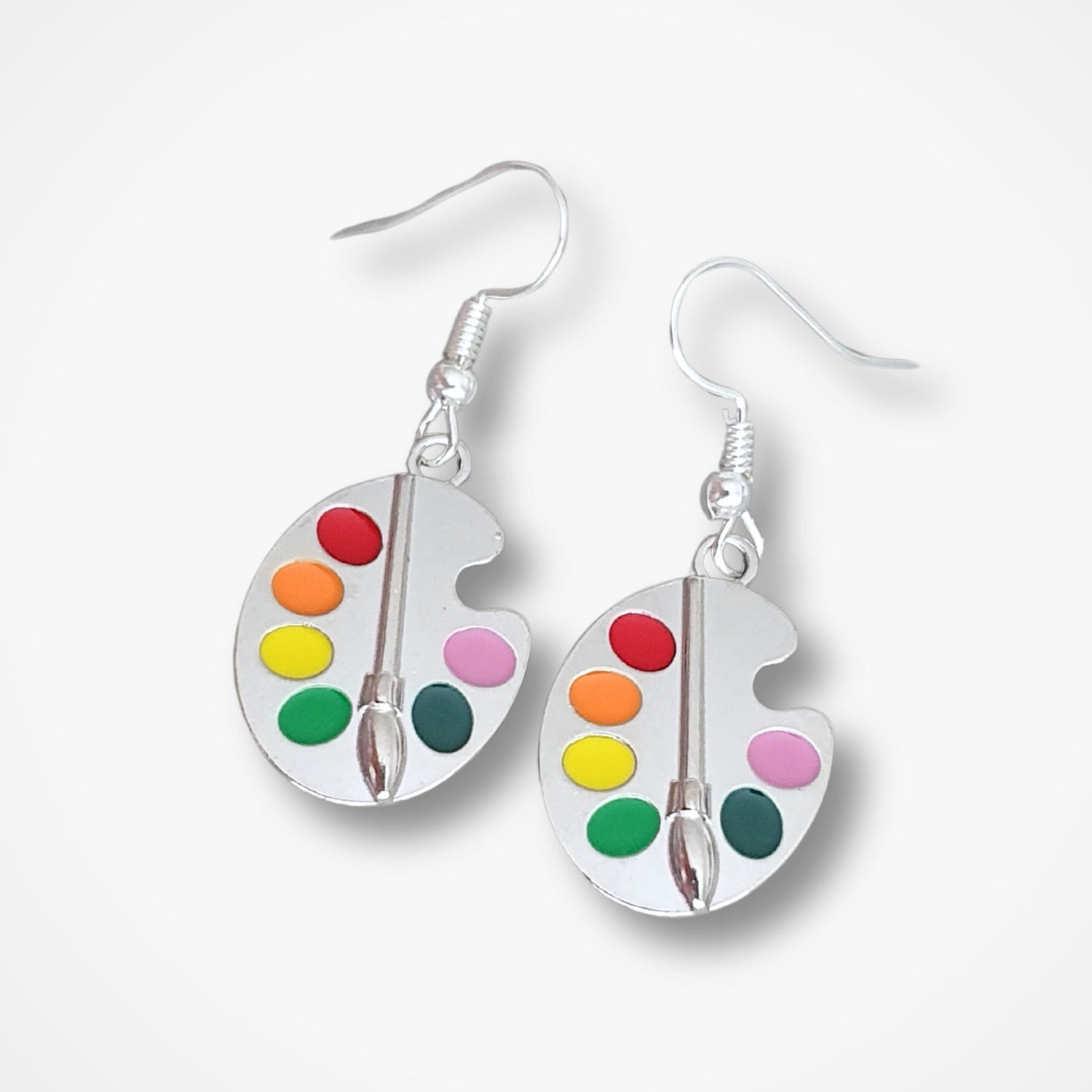A pair of silver-plated paint palette earrings with colorful enamel dots and a paintbrush design in the center.