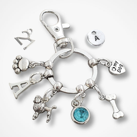 Silver keychain with poodle and various dog charms on a white background