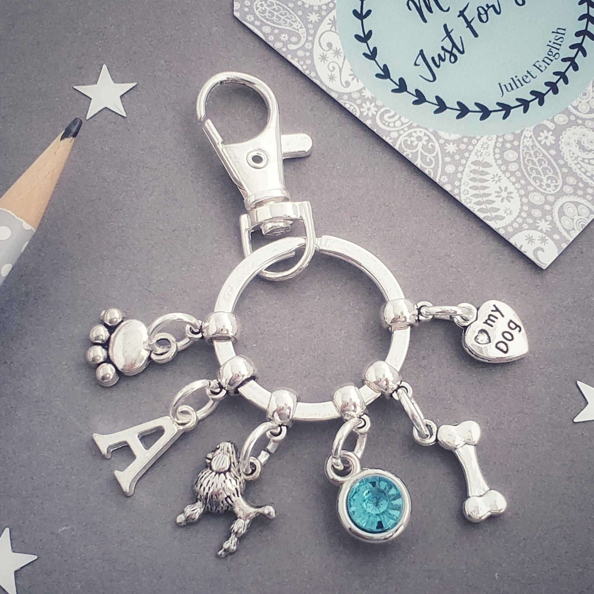 Keychain with poodle and various dog charms on a gray background