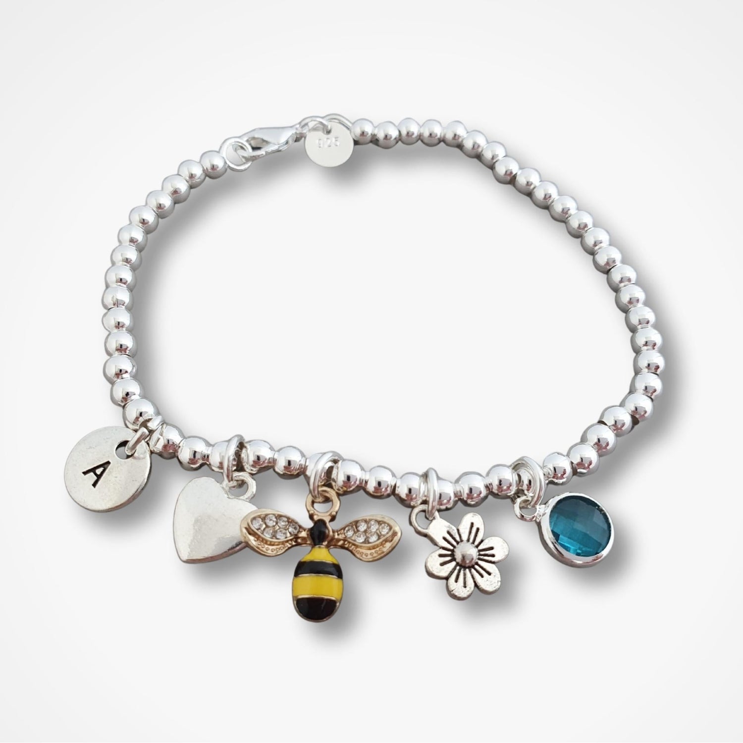 Silver bracelet with various charms on a white background