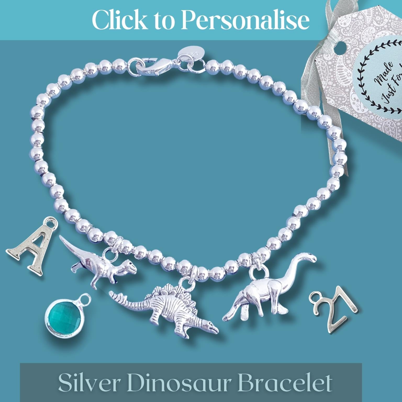Silver dinosaur bracelet with charms on a blue background