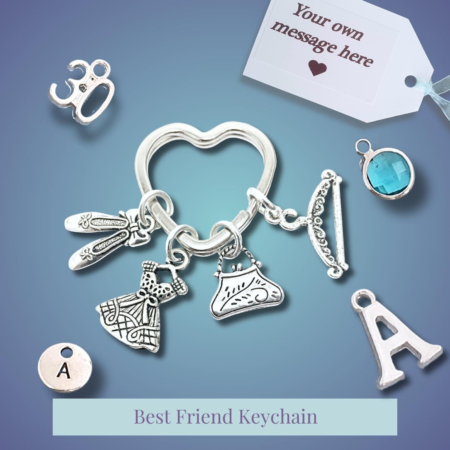 Silver-tone best friend keychain with multiple charms including a heart-shaped ring, keychain ring, initial 'A' charms, a small blue gemstone charm, and other decorative metal charms, displayed on a blue gradient background with a custom message tag.