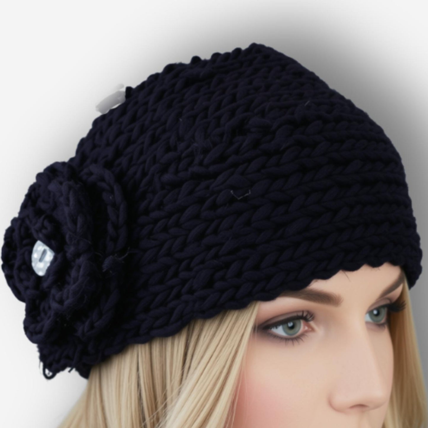 A chunky knit black headband with a large flower applique on the side, shown on a blonde mannequin head against a light gray background.