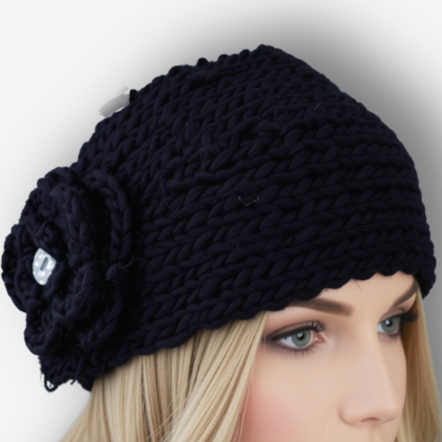 A chunky knit black headband with a large flower applique on the side, shown on a blonde mannequin head against a light gray background.