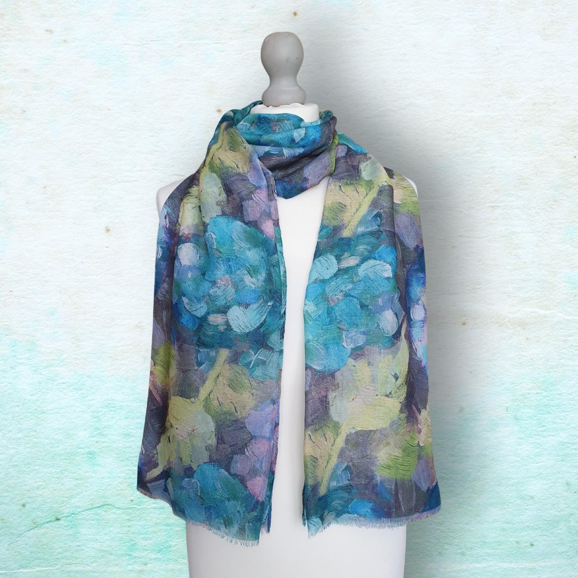 Mannequin wearing a blue and green floral patterned scarf against a light background