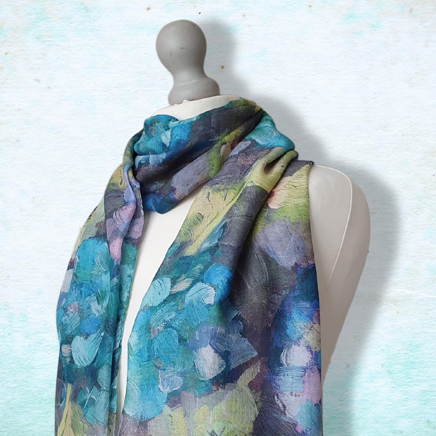 Mannequin wearing a colorful floral-patterned scarf against a light blue background