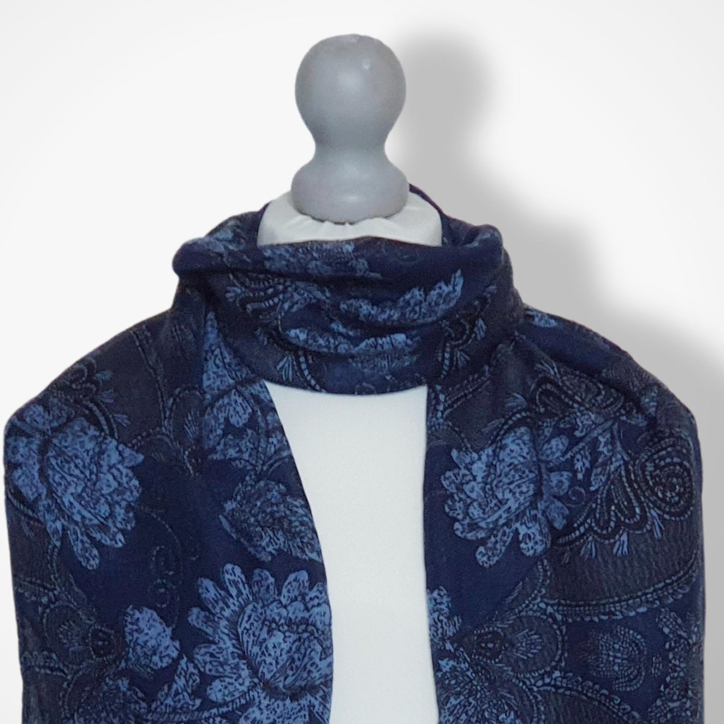 Navy blue floral patterned scarf on a mannequin against a white background