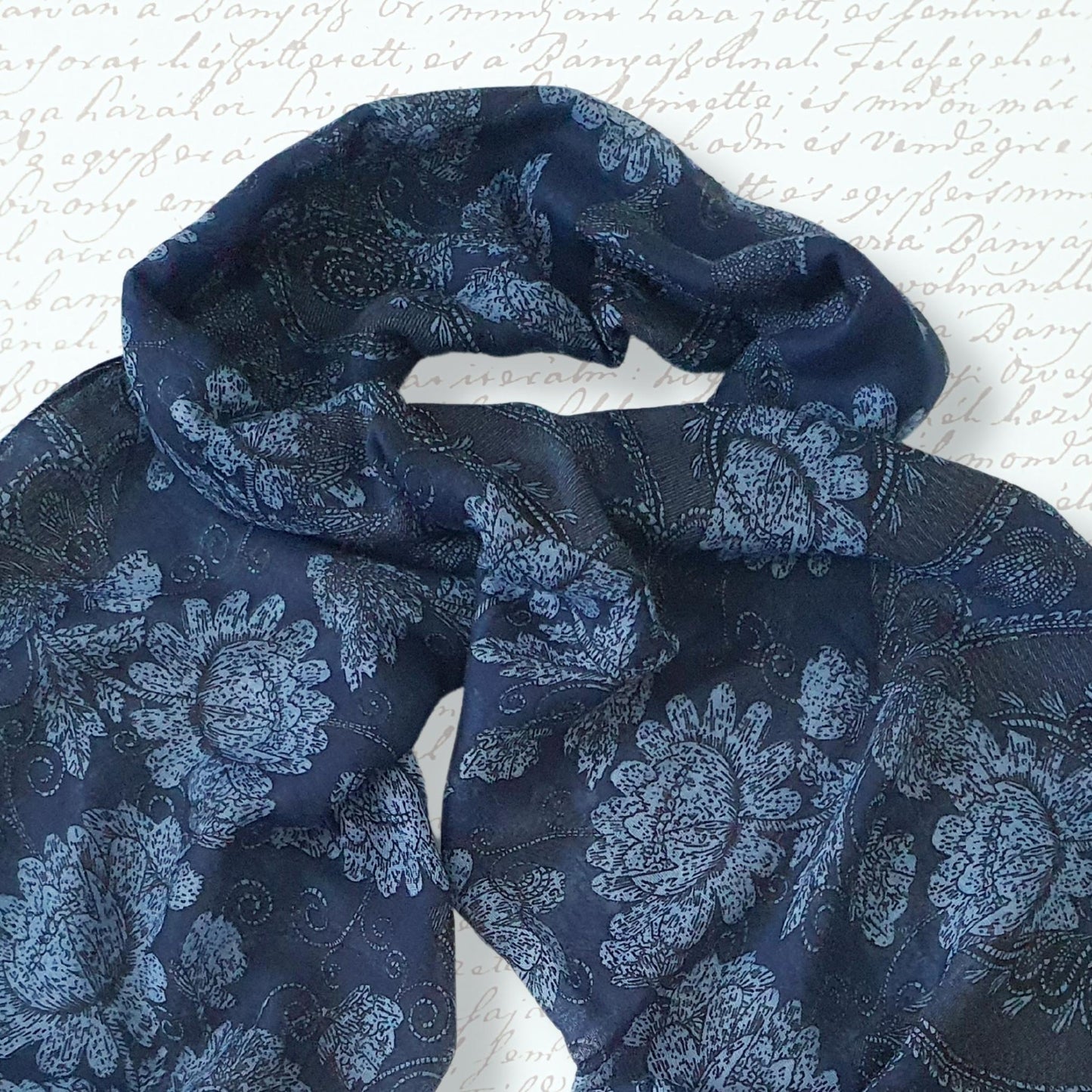 Blue patterned scarf on a textured white background