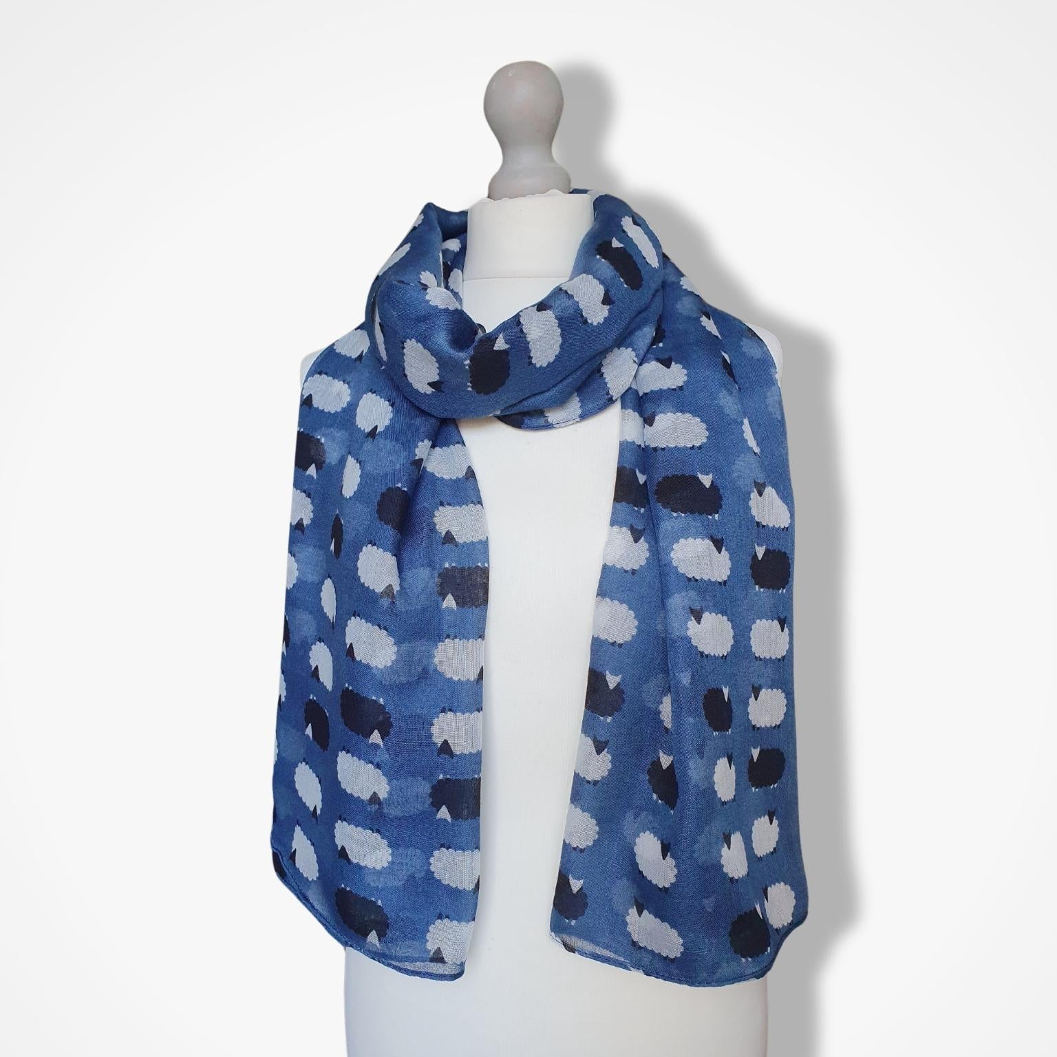 Blue scarf with sheep pattern on a mannequin against a white background