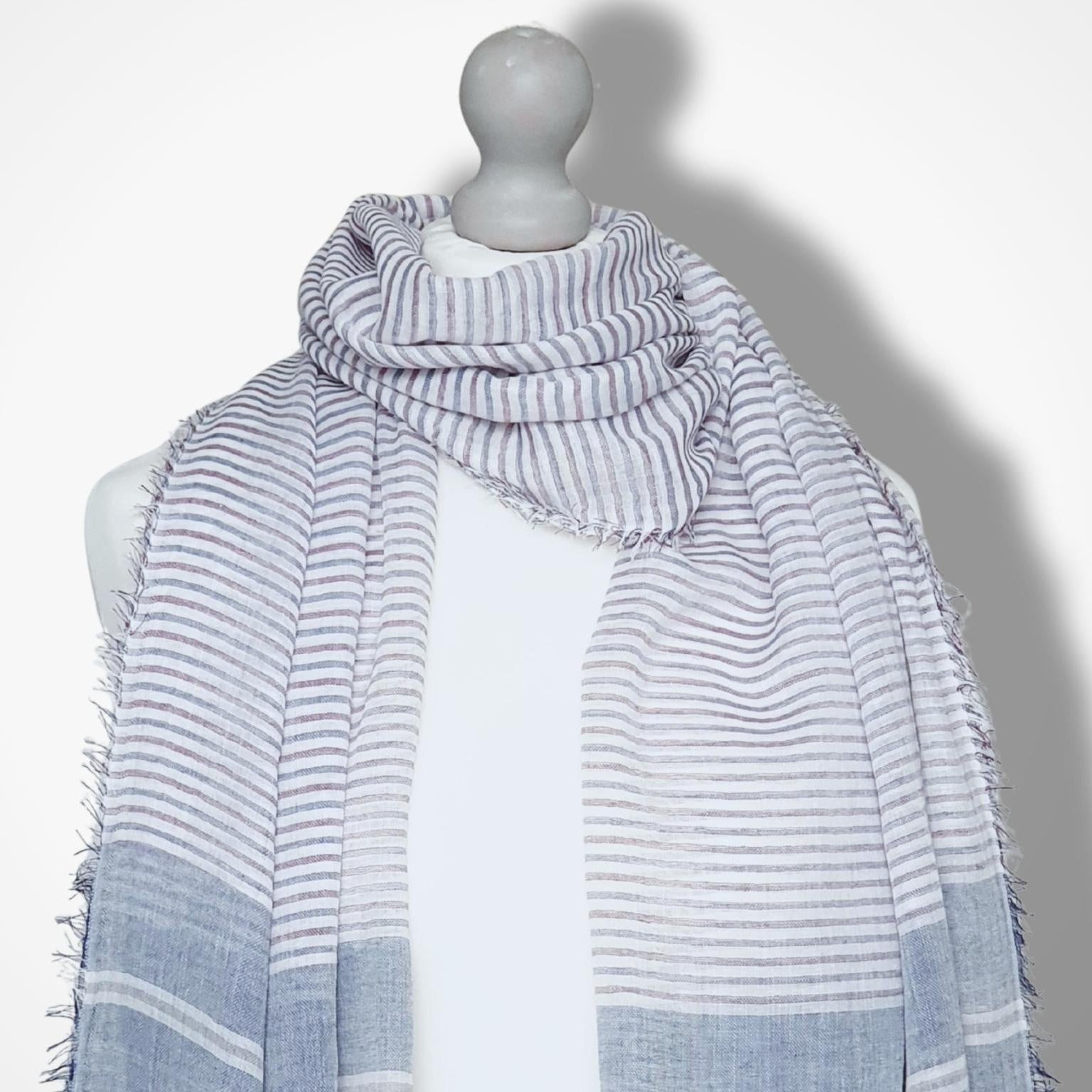 Mannequin wearing a striped scarf on a white background
